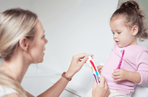 Māte māca savam bērnam, kā tīrīt zobus ar zobu birsti